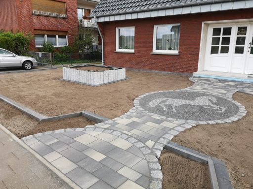 Hauseingang in einem Vorgarten mit Motivpflasterung