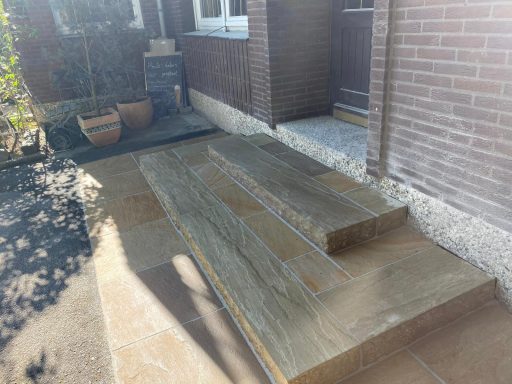 Treppe mit Natursteinplatten und Pflasterung im Eingangsbereich