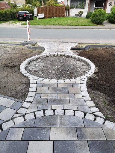 Geschwungene Pflasterfläche in einem Vorgarten mit Musterung