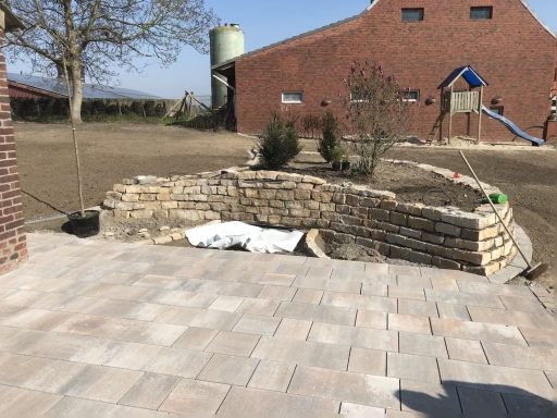 Gepflasterte Terrasse mit Hochbeet aus Naturstein