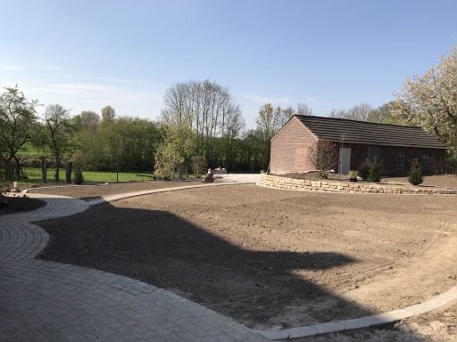 Frisch angelegte Pflasterfläche mit angrenzendem Gartenbereich