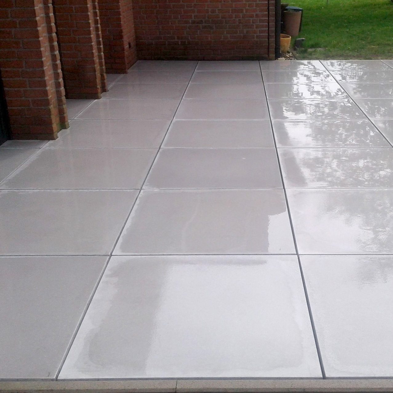 Moderne Terrassenplatten in heller Optik vor einer Hauswand