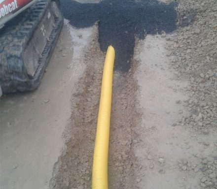 Drainagerohr in einem frisch ausgehobenen Schacht