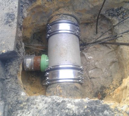 Rohr mit Verbindungsmanschette aus Metall in einer Baugrube