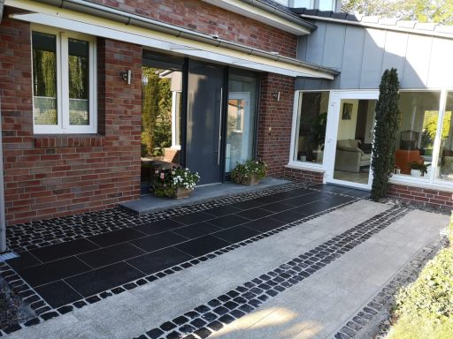 Moderner Gehweg mit rechteckigem Pflaster und Natursteinstreifen