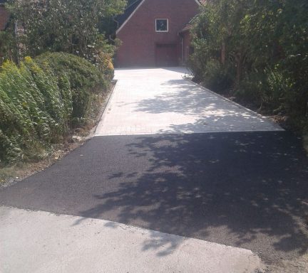 Frisch asphaltierte Hoffläche mit angrenzenden Pflasterarbeiten